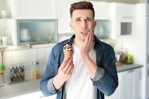 Man with toothache holding an ice cream 